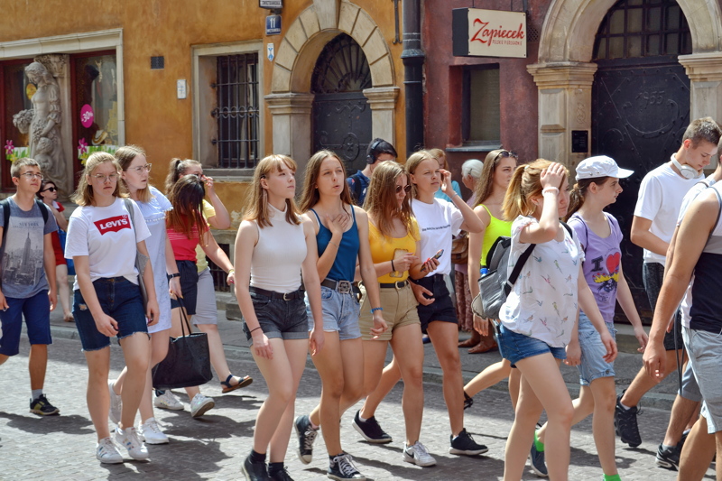 5 - A crowd of people walking down a sunny street in Warsaw, Poland